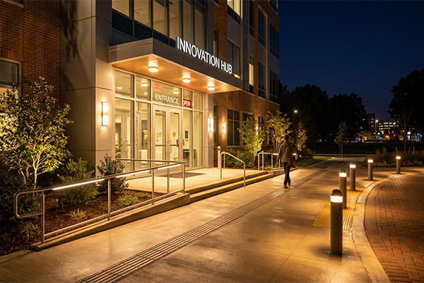 A well-lit building entrance and walkway at night